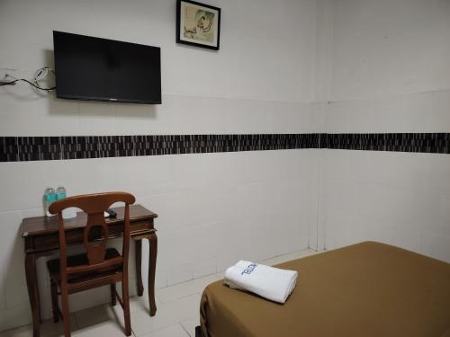 Una habitación con una mesa y una silla y un televisor. en E657 SERi TERUNTUM, en Kuantan