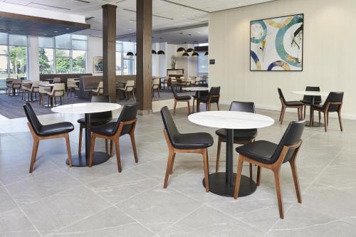 a waiting area with tables and chairs and tablesktop at Hyatt Place Toronto Mississauga and Luxe Convention Centre in Mississauga