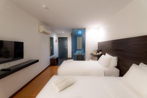 Ένα ή περισσότερα κρεβάτια σε δωμάτιο στο T+ Hotel Sungai Petani