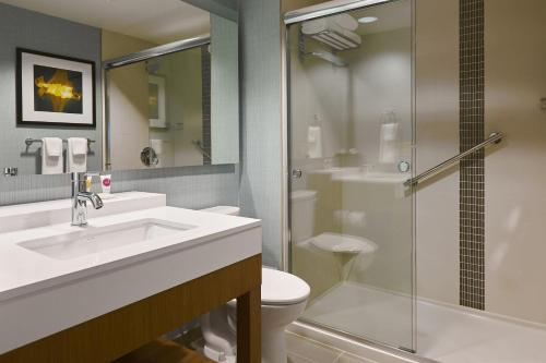 a bathroom with a toilet and a sink and a shower at Hyatt Place Toronto Mississauga and Luxe Convention Centre in Mississauga