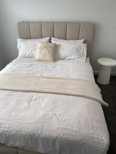 a large bed with white sheets and a pillow at Springvale 3 Bedroom Town House - Best Location in Springvale