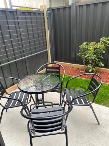 two chairs and a table and a table and chairs at Springvale 3 Bedroom Town House - Best Location in Springvale