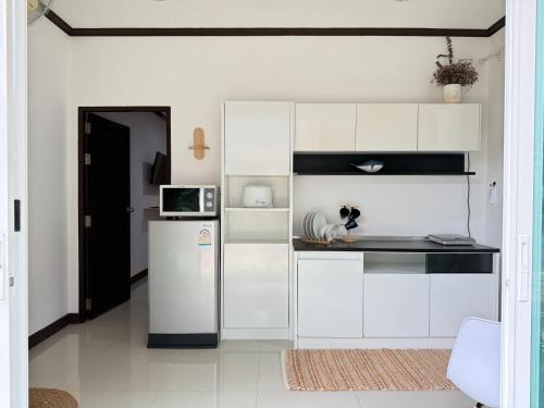 カマラビーチにあるJungle style apartments in Kamalaの白いキャビネットと冷蔵庫のあるキッチン