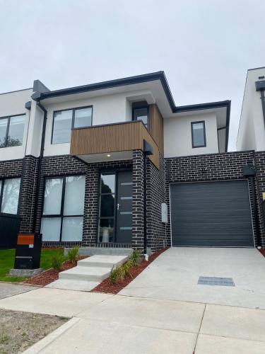a brick house with a garage at Springvale 3 Bedroom Town House - Best Location in Springvale