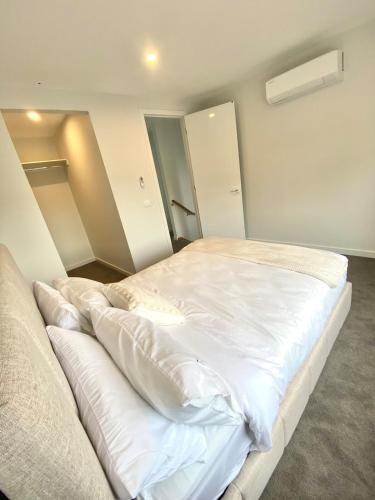 a bedroom with a large white bed in it at Springvale 3 Bedroom Town House - Best Location in Springvale