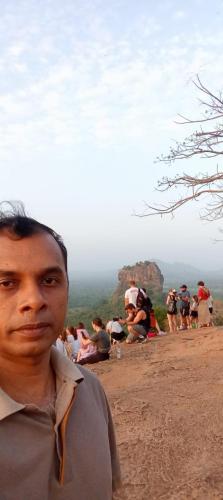 a man standing on top of a mountain at Peacock Lake Villa in Habarana