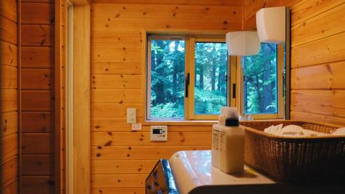 a bathroom in a log cabin with two windows at Private Retreat Nagano Iizuna 