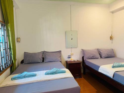 a room with two beds and a clock on the wall at Easy Home Koh Rong in Koh Rong