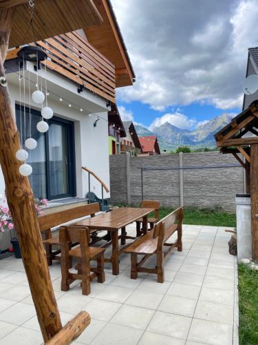 a wooden picnic table and benches on a patio at Vila Mima in Nová Lesná