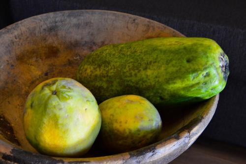 a wooden bowl filled with pomegranates and mangoes at Apartments Mitterhof 1544 in Brunico