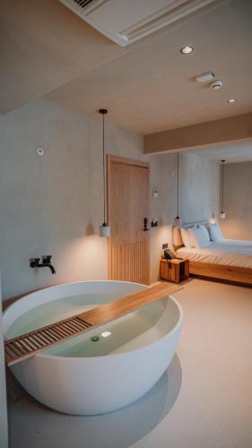 a large white bath tub in a room with a bed at La Gaia - Adult Only in Alanya