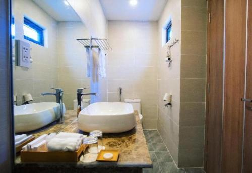 a bathroom with two sinks and a tub and a shower at Gold View Boutique Hotel Đà Lạt in Da Lat