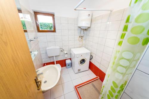 a bathroom with a sink and a washing machine at Apartments Borik in Zadar