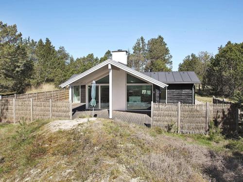 a small house on a hill with a fence at Tranquil Retreat in Nature - By Traum Ferienwohnungen in Ålbæk