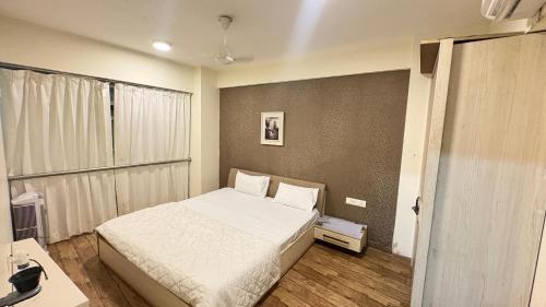a small bedroom with a bed and a desk at 7 Star homes at Rajhans Belliza in Surat