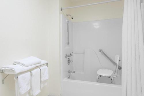 a white bathroom with a shower and towels at Super 8 by Wyndham Fayetteville in Fayetteville