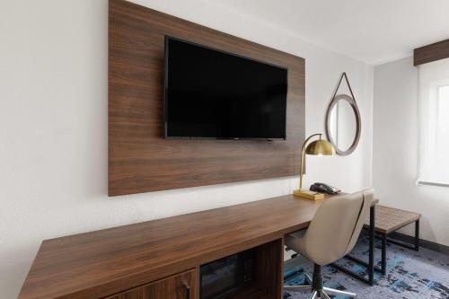 a living room with a television on a wall at La Quinta by Wyndham Springdale in Springdale