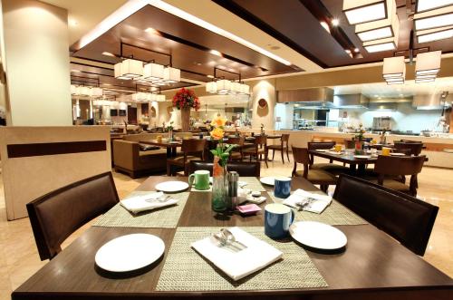 a dining room with tables and chairs in a restaurant at The LaLiT New Delhi in New Delhi