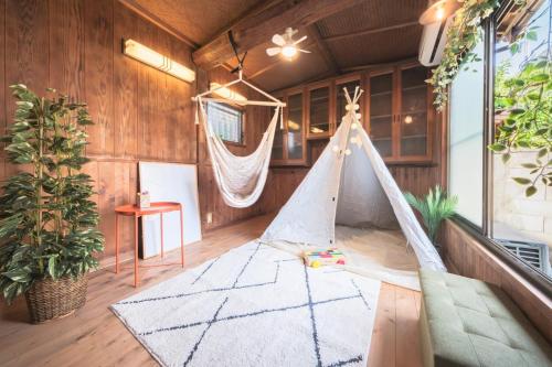 a hammock in a room with wooden walls at Laughter in Fuchu