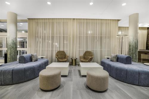 a lobby with two beds and two chairs and tables at Hilton Garden Inn Nashville Opryland in Nashville