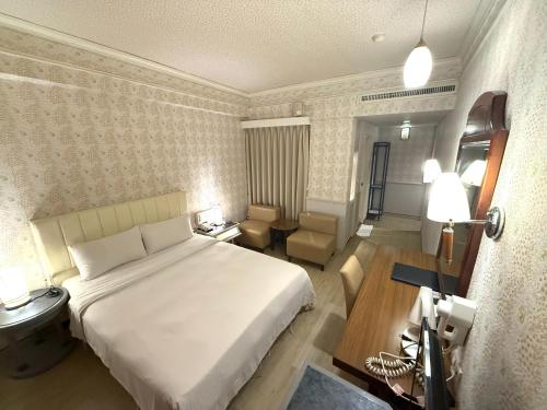a bedroom with a large white bed in a room at 種子商旅 in Kaohsiung