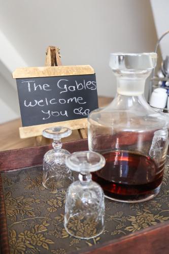 a bottle of whiskey and two glass jars on a table at The Gables-Clarens in Clarens