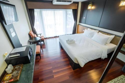 a hotel room with a bed and a television at LANDMARK NAKHONPHANOM HOTEL in Nakhon Phanom