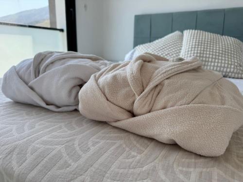 a blanket laying on top of a bed at Penthouse in Lapta, a Cozy Coastal Retreat in Lapithos
