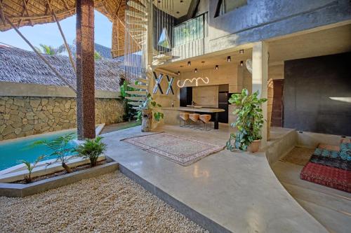an outdoor living room with a fireplace and a swimming pool at Happiness Kulambo Villa El Nido in El Nido