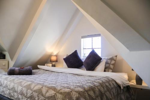 a bedroom with a large bed with purple pillows at The Gables-Clarens in Clarens