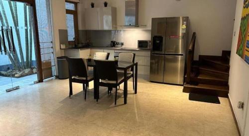 a kitchen with a table and chairs and a refrigerator at D Villas in Colombo
