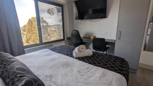 Ένα ή περισσότερα κρεβάτια σε δωμάτιο στο Cooma High Country Motel