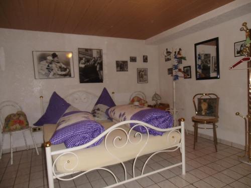カッペル・グラーフェンハウゼンにあるGästehaus Baurのベッドルーム(紫色の枕が付くベッド付)
