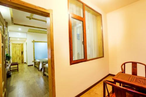 a hallway with a room with a bed and a mirror at Wulingyuan Zhangjiajie National Forest Park Qique Villa in Zhangjiajie