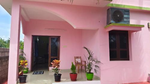 a pink house with plants in front of it at kanyakumari home stay in Jāmb