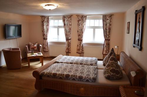a bedroom with a bed and a couch and windows at Rathaus-Pension 1685 in Brandenburg an der Havel