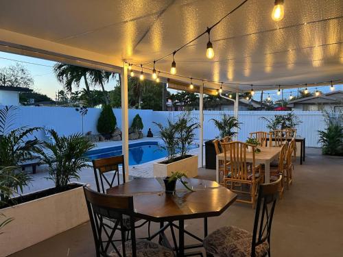 a patio with tables and chairs and a pool at The blue Homestay near Miami Airport in Miami