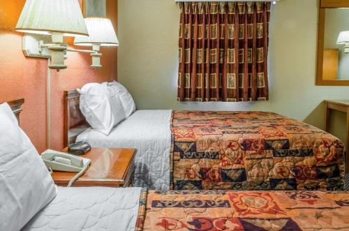 a hotel room with two beds and a table at Rodeway Inn Allentown South in Allentown