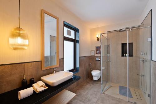 Un baño con lavabo, ducha e inodoro. en Melhor stays villas - L-S10 4BHK villa with private pool, Anjuna, en Anjuna