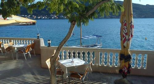 a table and chairs with a view of the water at Apartment Pilatus Ošljak in Preko
