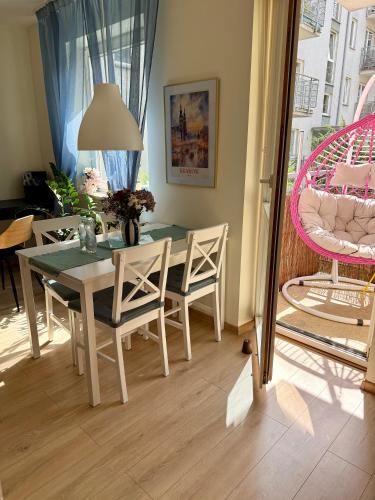 a dining room with a table and chairs and a pink chair at Kraków Nest in Kraków