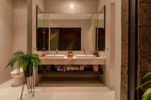 a bathroom with two sinks and a mirror at Sierra Vista 2 Ubud in Ubud