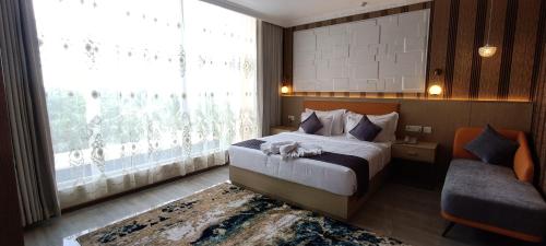 a bedroom with a bed and a large window at Montecarlo Hotel in Mahabalipuram