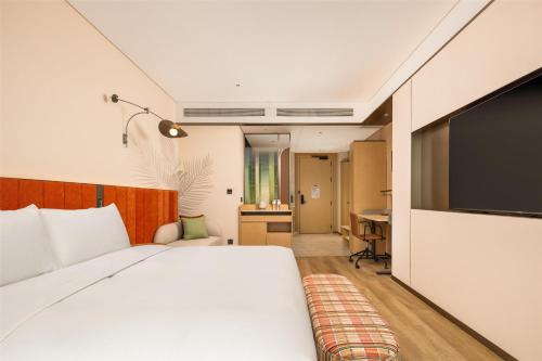 une chambre d'hôtel avec un lit et une télévision à écran plat dans l'établissement Hilton Garden Inn Olympic Sports Center Jinan, à Jinan