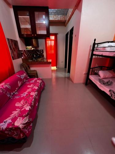 a room with bunk beds and a kitchen with a red door at DC Travellers Inn in Malolos