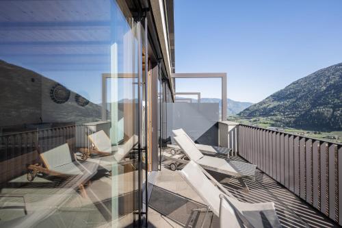 a balcony with white chairs and a view of mountains at Paloria Apartments & Sport in Lagundo