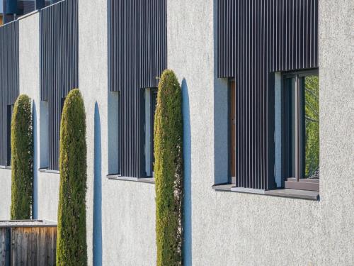 a building with a row of trees and windows at Paloria Apartments & Sport in Lagundo