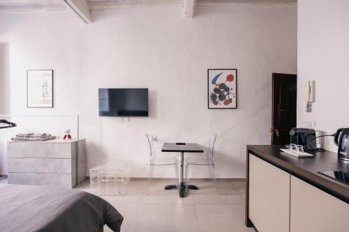 a bedroom with a bed and a kitchen with a table at Studio d'Art - Centro Storico di Arezzo in Arezzo