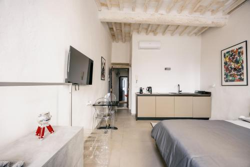 a white bedroom with a bed and a sink at Studio d'Art - Centro Storico di Arezzo in Arezzo