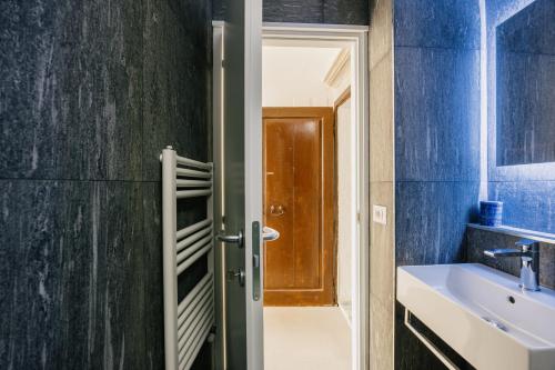 a bathroom with a sink and a wooden door at Studio d'Art - Centro Storico di Arezzo in Arezzo